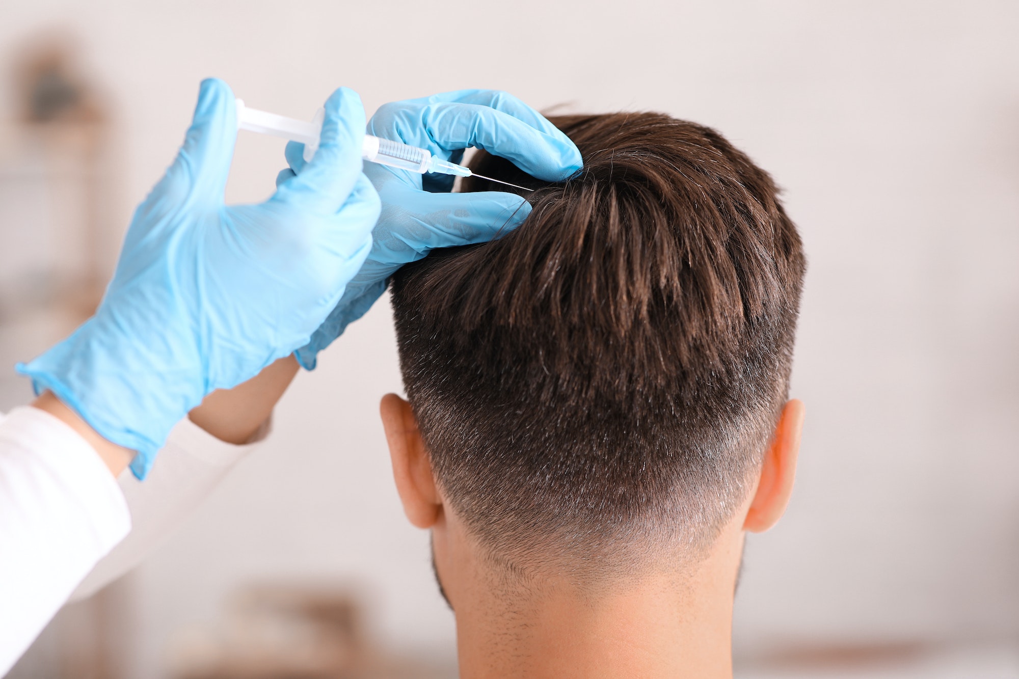 Back view of man having hair treatment at beauty salon